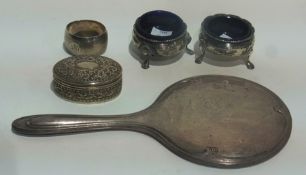 A silver backed hand mirror, an oval pill box, a pair of open salts and a napkin ring (5)