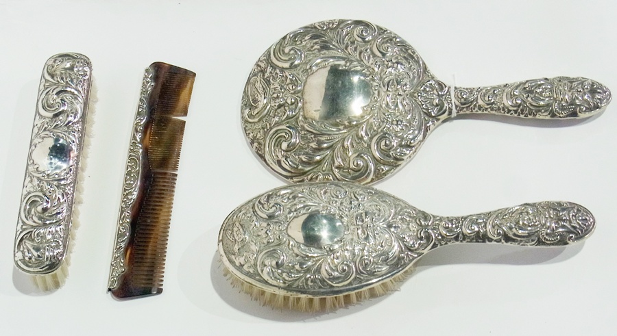 A silver backed dressing table set comprising:- hairbrush, hand mirror, clothes brush and comb,