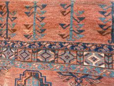 Caucasian style Eastern wool rug, with stepped guls and hooked motifs on a rust-coloured ground,