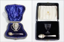 George V silver stylised three-handled egg cup and spoon, London 1912, in fitted case, together with