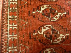 Eastern small wool rug with two rows of stepped guls, on a red ground