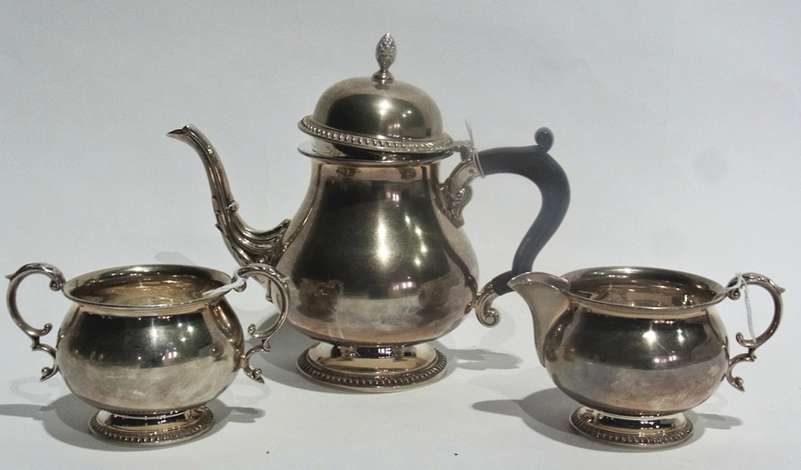 Silver three-piece teaset of plain baluster form with gadrooned borders, comprising a teapot,