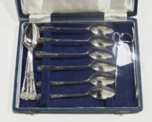 A set of twelve silver coffee spoons, mask head pattern, with a pair of matching sugar tongs, in a