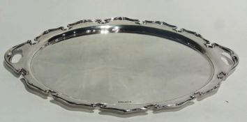An Edwardian silver oval tray with Art Nouveau design border and pierced twin handles, Sheffield