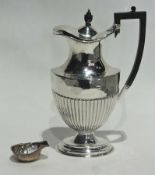 An Edwardian silver ewer shaped hot water pot with turned ebony finial and handle and half fluted