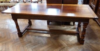 A reproduction oak refectory table, the three-plank top with clisset ends, with foliate carved