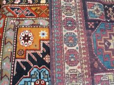 Small eastern wool rug with stylised flowerhead medallions and another with two octagonal medallions