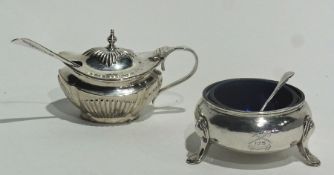 Circular silver open salt with blue glass liner, raised on pad feet with spoon, London 1912 together