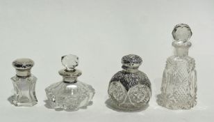 A collection of cut glass silver capped scent bottles, various together with a plain glass scent