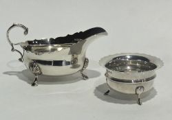 A Georgian style silver gravy boat with cut-card borders, scroll handle with pad feet, London