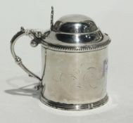 A white metal tankard mustard pot with domed hinged cover and blue glass liner