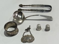 A Georgian silver gravy ladle, silver napkin ring, two silver thimbles and a silver Whisky label,