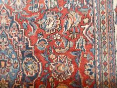 Eastern wool rug with floral arabesques to the field and having blue spandrels, herati borders,