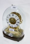 Nineteenth century brass skeleton clock, on scroll supports, mahogany plinth base, under glass dome