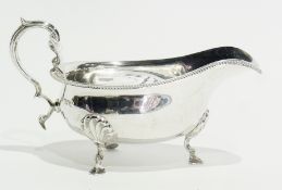 A Georgian style silver sauceboat, with reeded border, scroll handle, raised on cabriole legs with