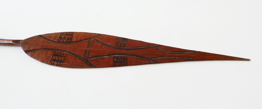 Carved wooden paddle, with pierced and pointed handle, and carved spear