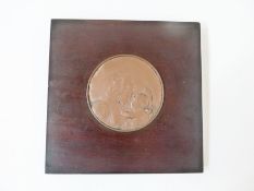 Circular bronze religious plaque of Mary and Child, mounted on square wooden frame, 16cm diameter