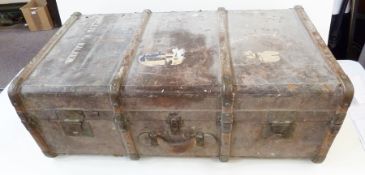 Large wooden brass bound trunk, with worn label