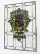 Rectangular stained glass window of family crest, with Matilda in green and yellow, with lion to