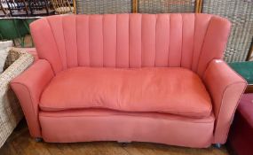 A contemporary three seater sofa, with pink upholstery with loose cushion seat on casters, width