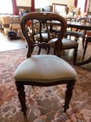 A set of 10 Victorian mahogany balloon back chairs with foliate and C-scroll carving, upholstered