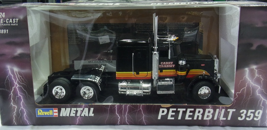 A 1/24 scale Revell diecast model of a Peter Bilt 359 truck and another, and a boxed trailer,