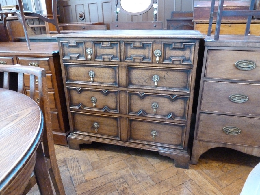 A reproduction oak late seventeenth century style chest of drawers, with moulded edge top, geometric
