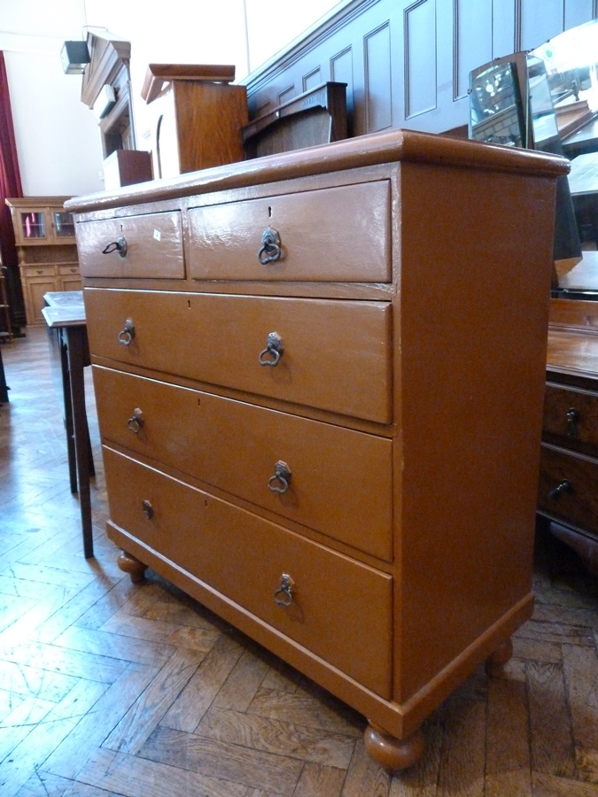 A Victorian painted pine chest of two short and three long graduated drawers raised on bun feet,
