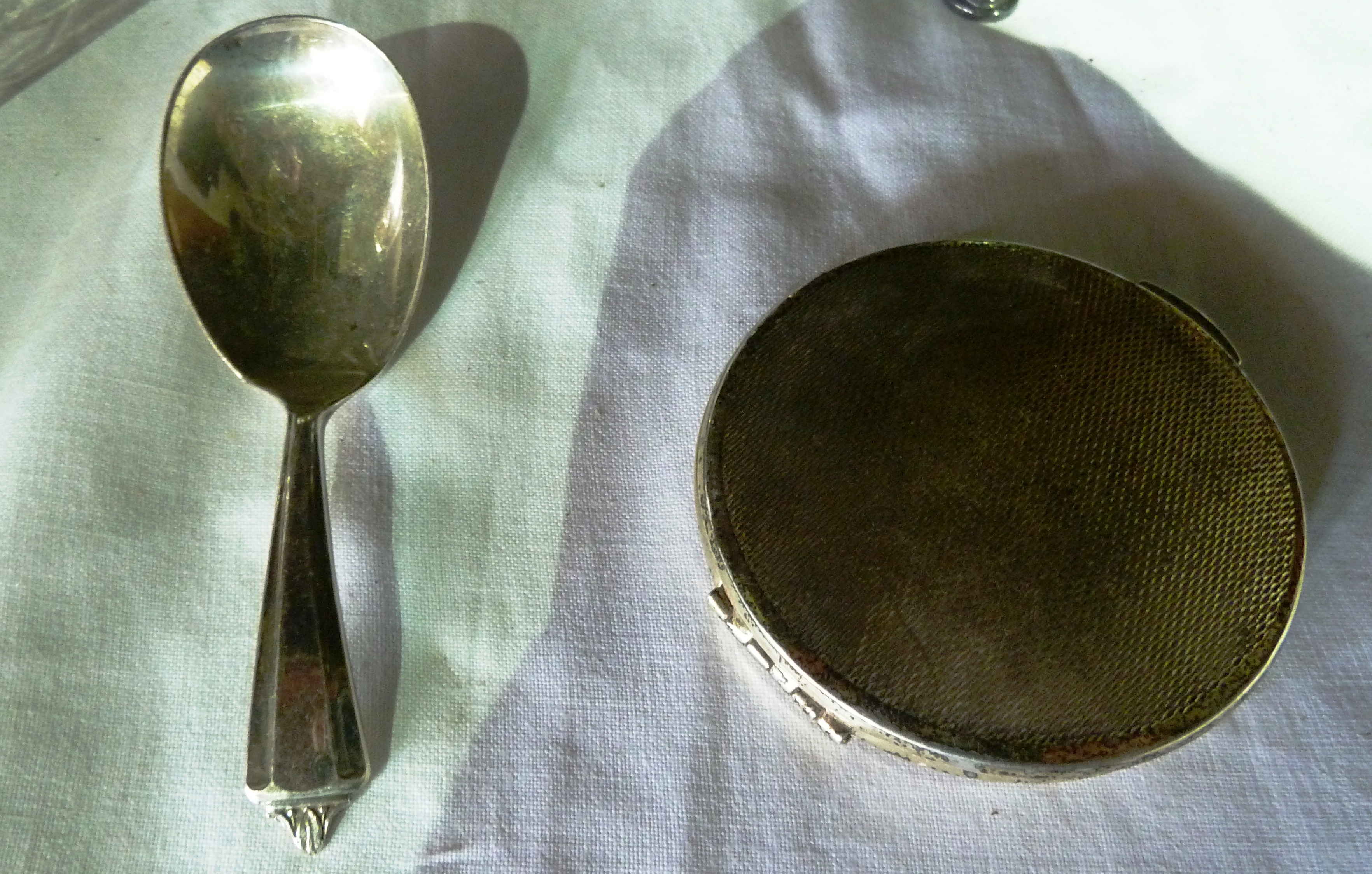A lady's silver compact with engine turned engraving, together with a silver caddy spoon