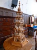 An Indian style carved pine light stand, with revolving central column, with three shelves, raised