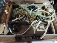 Large quantity of costume jewellery in leather jewellery box, to include beaded necklaces, brooches,