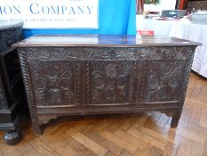 A seventeenth century carved oak coffer, with moulded edge top, carved foliate frieze and panelled