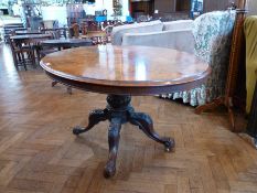 A Victorian oval burr walnut loo table with turned and carved pedestal support to four splayed
