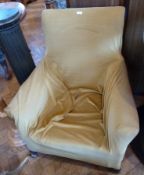 An old armchair with mustard coloured loose cover, on square legs with casters
