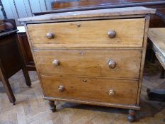 A Victorian pine chest of three long graduated drawers raised on turned legs, width 52cms