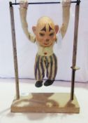 French papier mache and fabric automaton acrobat, wearing white jacket and blue and white striped