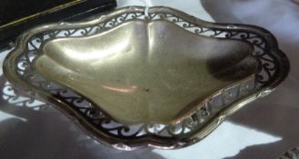 A silver bonbon dish with pierced scrollwork border, raised on scroll feet, London 1906, length