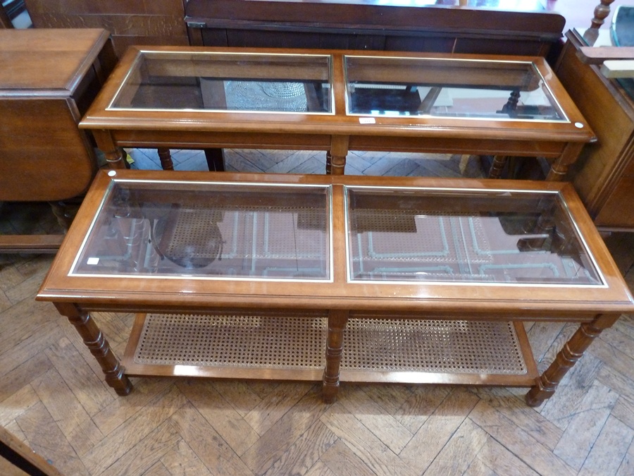 A modern glass top side table on turned legs with cane shelf below together with a matching coffee