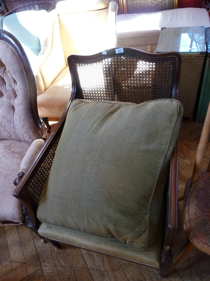 Mahogany Bergere armchair, single cane back and sides, green upholstery and loose cushions, on