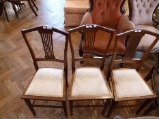 Three inlaid Edwardian mahogany bedroom chairs, each with pierced splat back, padded seat, on square