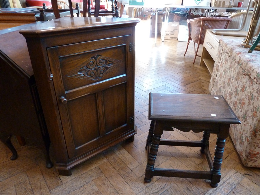 A reproduction oak corner cupboard, the carved panel door enclosing shelf, together with an oak