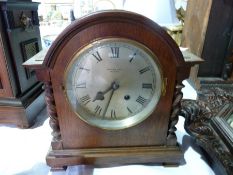 "John Bull and Co Bedford" oak mantel clock, in broken arch top case with spirally turned fore