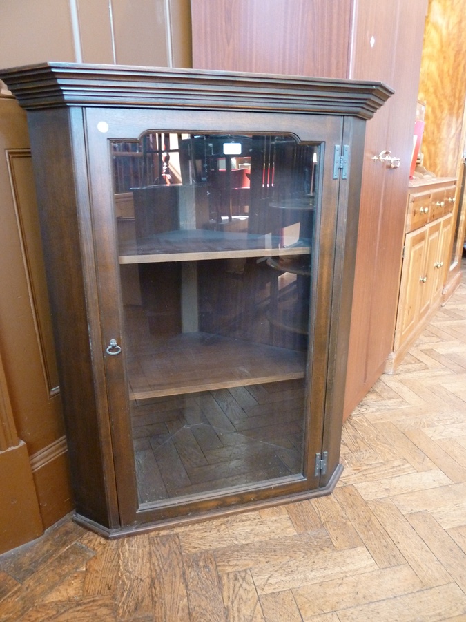 A 20th century oak corner cupboard, the glazed door enclosing three shelves, 89 cm wide