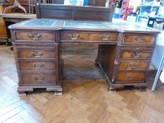 A reproduction mahogany pedestal desk, with inset writing surface, three frieze drawers flanked by