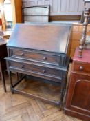 A twentieth century stained oak bureau with fitted interior, frieze drawer, with further drawer