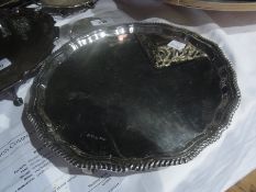 A silver salver with gadrooned wavy border raised on scroll feet, Sheffield 1973, diameter 26cms,