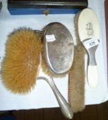 A silver backed made up dressing table set comprising hand mirror, clothes brush and a pair of