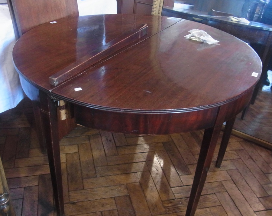 A Georgian mahogany D-end dining table, with two leaves,plain frieze on square tapering legs,