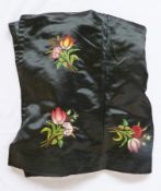 A Victorian black satin "dress" apron, embroidered with tulips and carnations in bunches, pockets