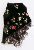 A Victorian black velvet triangular shawl, embroidered with flowers, trailing pattern with buds